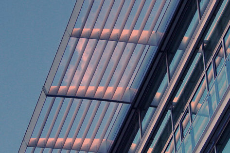 Photo d'un auvent au dessus d'un building avec façade vitrée