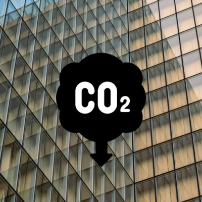 Logo CO2 en baisse devant un bâtiment avec une façade vitrée